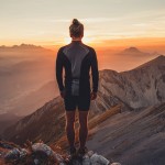 Male hiker observing the sunset at the top of the local big moun