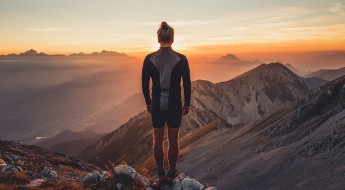 Male hiker observing the sunset at the top of the local big moun